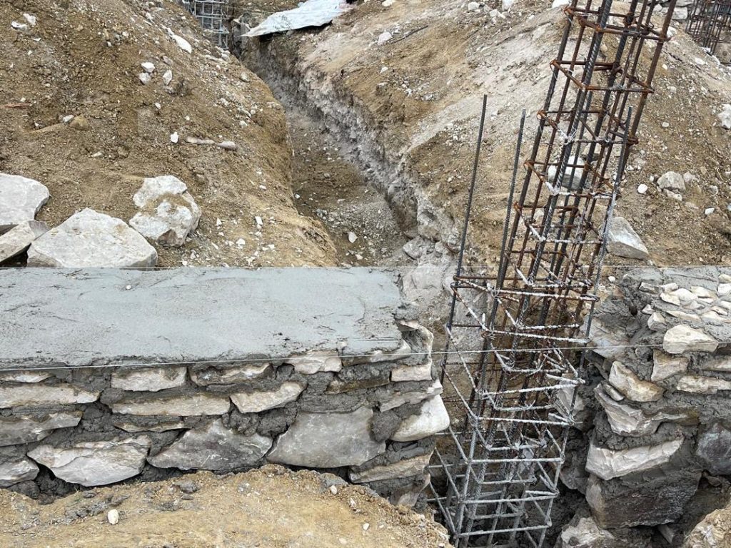 Close view of a stone foundation and reinforced column cage