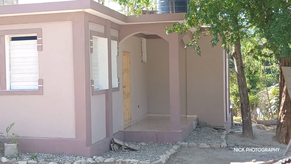 Completed presbytery in Guinaudée showing the covered entrance and finished exterior.