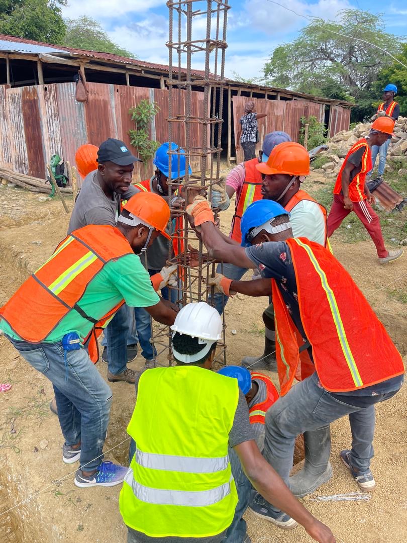 Workers carrying out active foundation work at the Sainte-Thérèse d’Avila church construction site in Guinaudée.